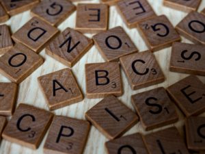 Scrabble letters scattered on the table with ABC visible to read. 